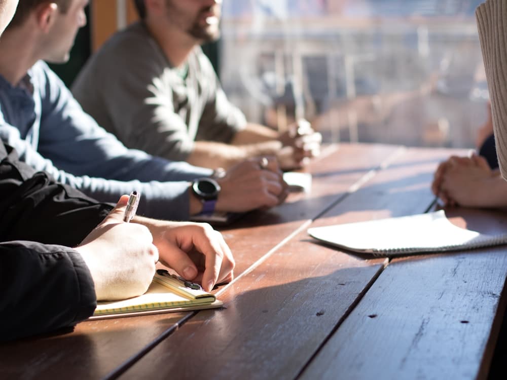 A hiring team taking notes during a requirement discussion