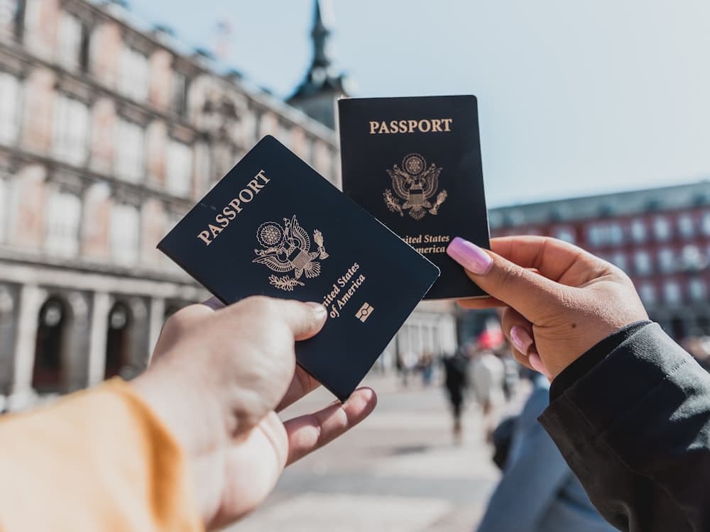 Two US passports held up in front of a city street